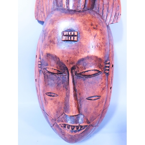 471 - A Northwest African Tribal mask mounted with a bird, 42cm x 18cm