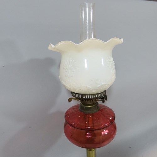 576 - Two Victorian oil lamps both with red glass fonts and brass columns.