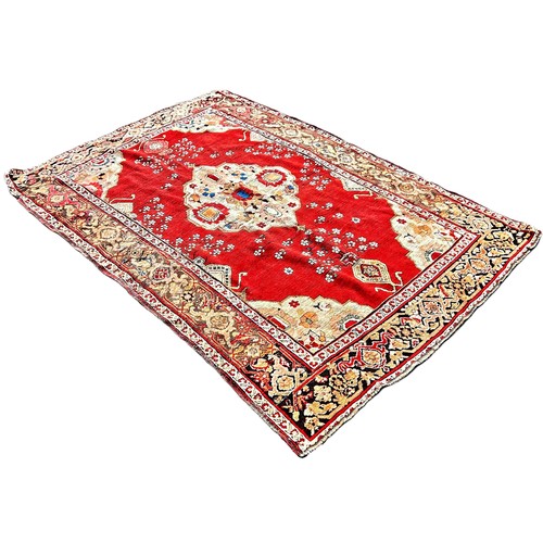 6007 - A Middle Eastern Karabagh rug with a central medallion on floral red ground, 208cm x 146cm approxima... 