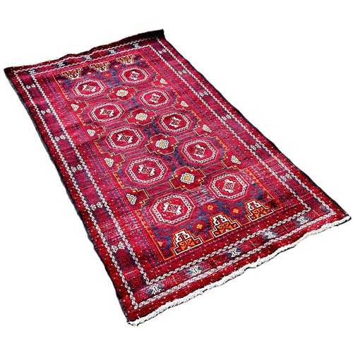 6012 - A Middle Eastern Baluch rug with alternating rows of guls 190cm x 108cm