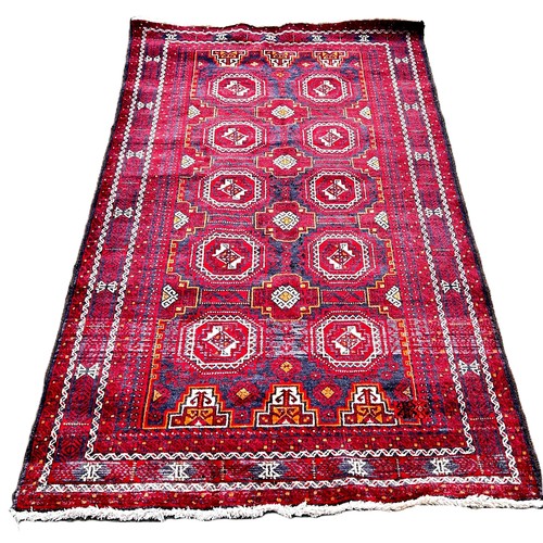 6012 - A Middle Eastern Baluch rug with alternating rows of guls 190cm x 108cm