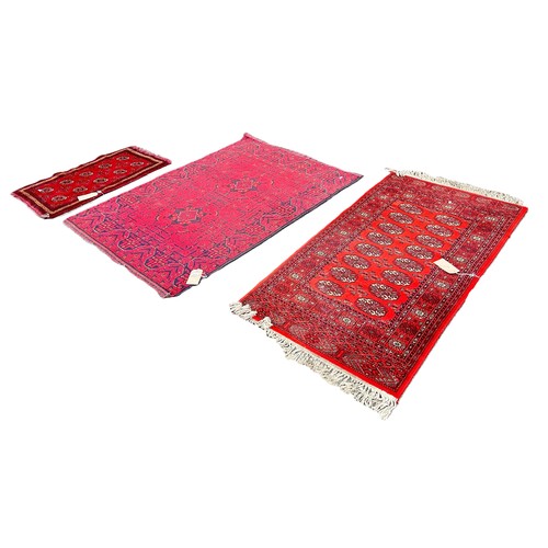 6030 - Three Afghan type carpets with elephant foot gul all with red grounds, 160cm x 109cm, 160cm x 84cm a... 