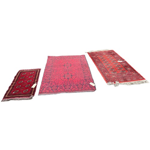 6030 - Three Afghan type carpets with elephant foot gul all with red grounds, 160cm x 109cm, 160cm x 84cm a... 