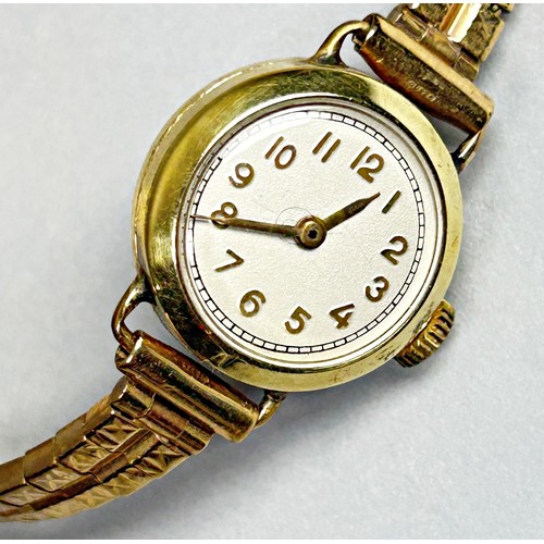 423 - A lady’s vintage yellow metal wristwatch, the silvered dial with golden Arabic numerals, 16mm case, ... 