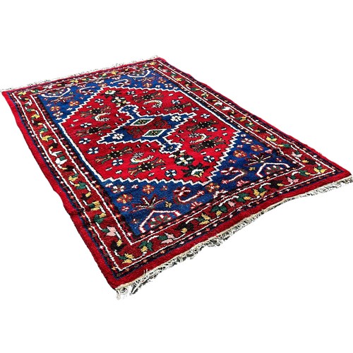 1650 - A thick pile wool Middle Eastern carpet, with an extended lozengeon a blue and red ground263cm x 171... 