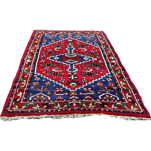 1650 - A thick pile wool Middle Eastern carpet, with an extended lozengeon a blue and red ground263cm x 171... 