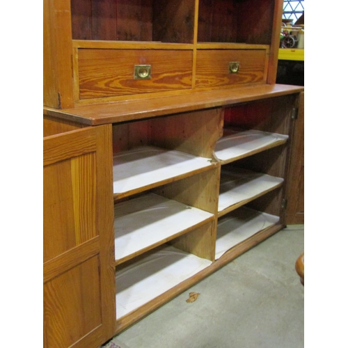 1074 - A pitch pine dresser in two sections, the lower enclosed by a pair of quarter moulded panelled doors... 