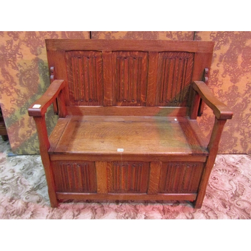 1164 - An oak monks bench with sliding top over hinged box seat with linen fold panels, 72 cm high x 107 cm... 