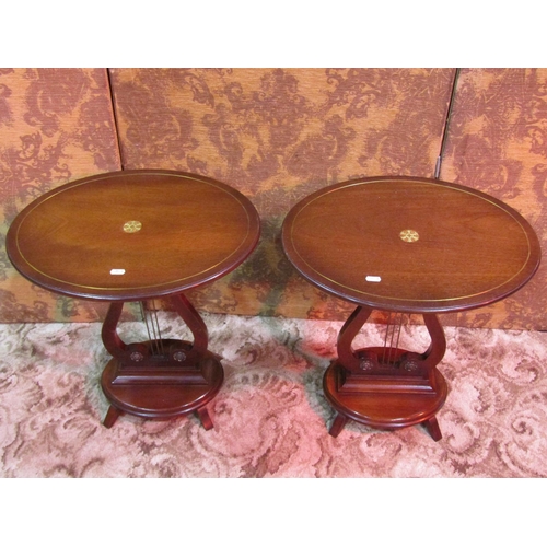 1167 - A pair of small reproduction Regency style occasional tables of oval form raised on lyre shaped supp... 