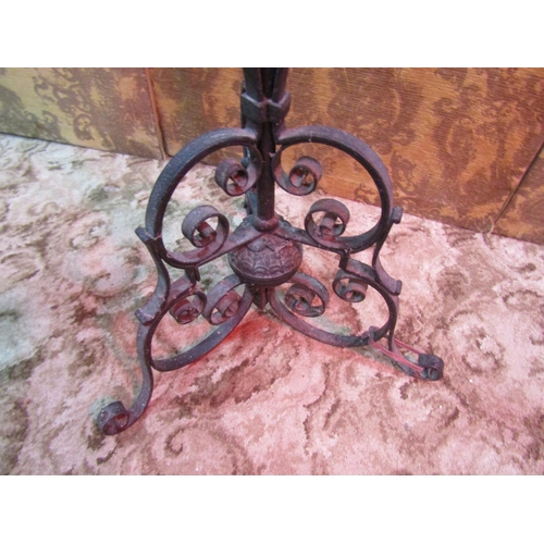 1175 - A heavy gauge wrought iron lampstand with open scrolled detail and supports, 154 cm high