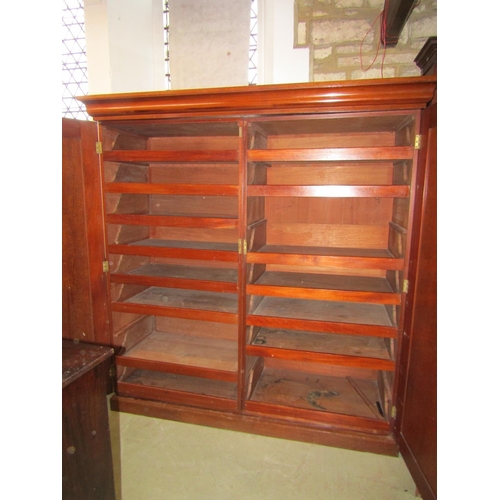 1300 - A Victorian two sectional mahogany wardrobe enclosed by a pair of full length rectangular fielded pa... 