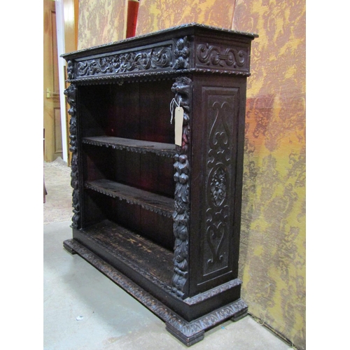 1315 - A Victorian Gothic carved oak freestanding open bookcase with two adjustable shelves, carved lions m... 