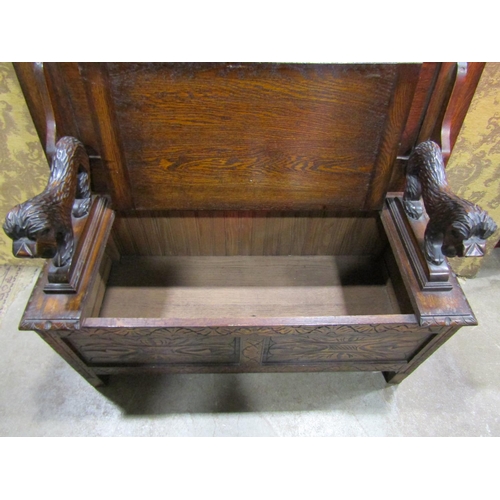 1320 - A carved oak monks bench with hinged box seat and carved lions supporting a sliding top, 72cm high x... 