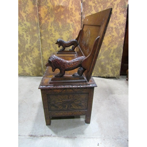 1320 - A carved oak monks bench with hinged box seat and carved lions supporting a sliding top, 72cm high x... 