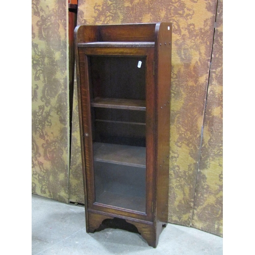 1322 - A small early 20th century Arts and crafts oak bookcase enclosed by a rectangular glazed panelled do... 