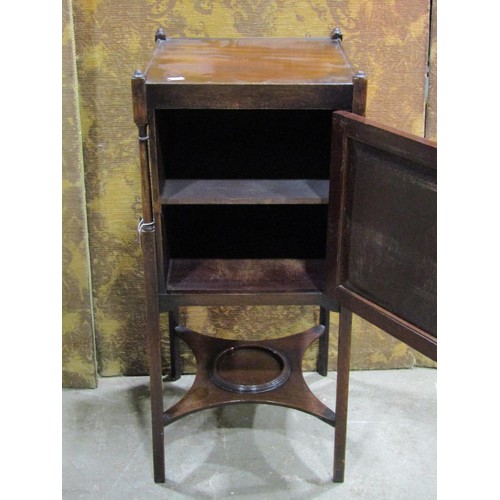 1342 - A mahogany bedside cabinet in the Georgian style enclosed by a panelled door on square cut supports,... 