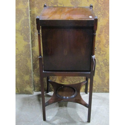 1342 - A mahogany bedside cabinet in the Georgian style enclosed by a panelled door on square cut supports,... 