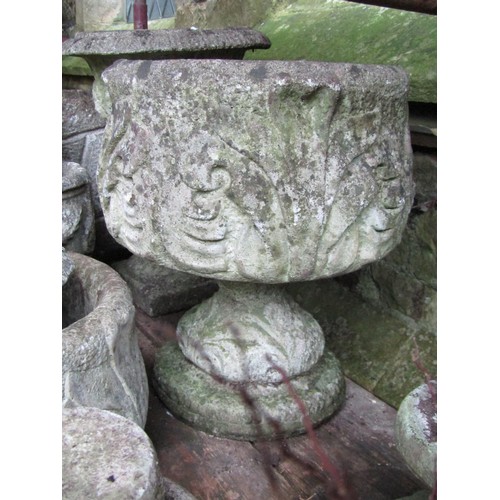 1014 - A collection of weathered cast composition stone garden urns and planers of varying sizes and design... 