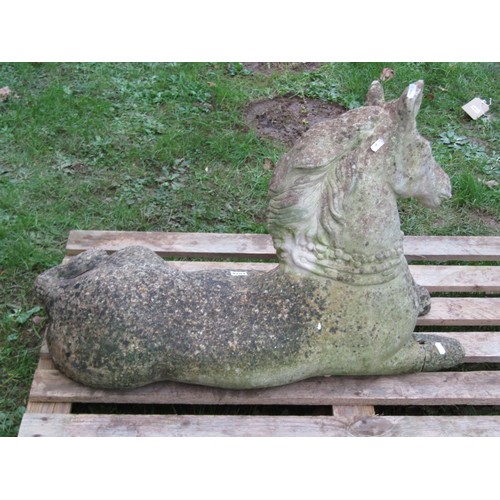 1028 - A weathered cast composition stone garden ornament in the form of a recumbent horse (af), 56 cm high... 