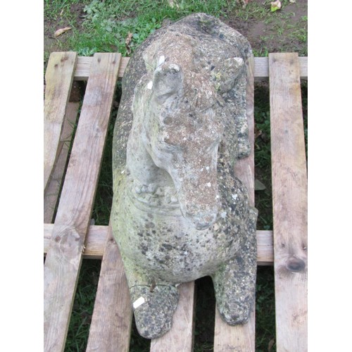 1028 - A weathered cast composition stone garden ornament in the form of a recumbent horse (af), 56 cm high... 