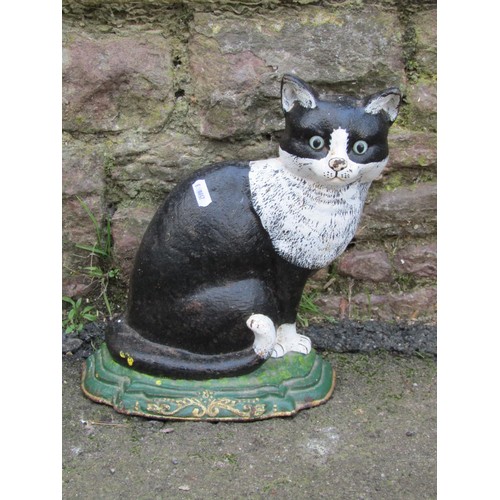 1060 - A painted cast iron door porter in the form of a seated black and white cat, 30 cm high, together wi... 