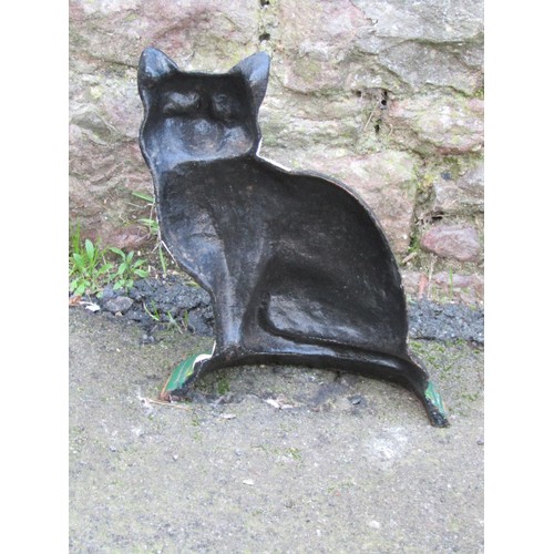 1060 - A painted cast iron door porter in the form of a seated black and white cat, 30 cm high, together wi... 