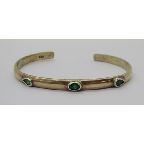 334 - 9ct bangle, London 1970, 15.9g (slightly misshapen) and a further 9ct torque bangle set with green g... 