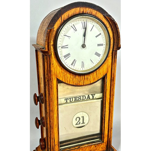 440 - A late Victorian / Edwardian oak cased table clock/calendar, 3.5” dial, 34cm high.