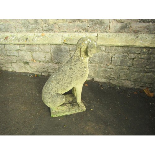 1053 - A weathered cast composition stone garden ornament in the form of a seated hound set on a rectangula... 