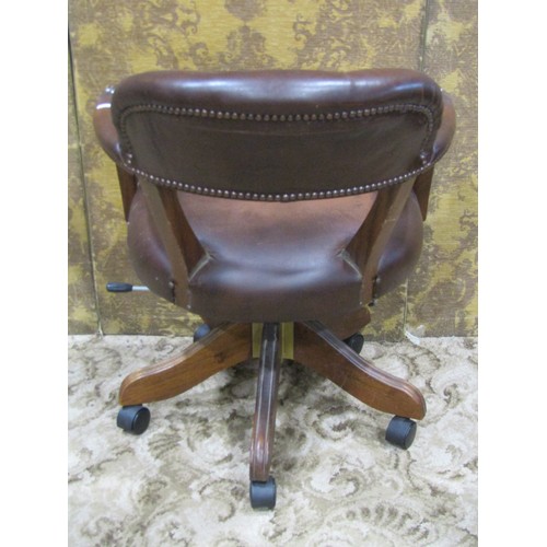 1269 - A reproduction swivel desk chair with horseshoe shaped button back