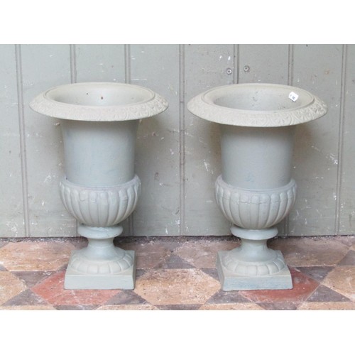 1014 - A pair of light green painted campana shape cast iron urns with flared rims, 34 cm high x 24 cm