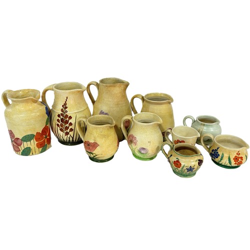 64 - A group of Radford pottery, decorated throughout with floral motifs, to include jugs, vases etc, (23... 