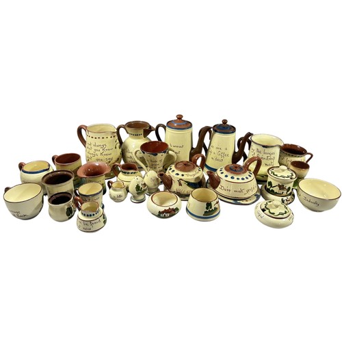 66 - A collection of Torquay pottery with motto script, coffee pots, tea pots, jugs and other vessels (35... 