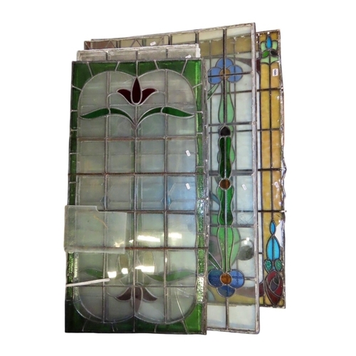 1041 - A collection of leaded and stained glass window panels with varying foliate design, (varying size, s... 