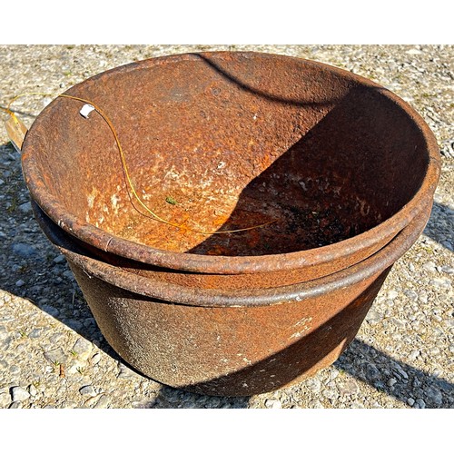 A pair of old weathered cast iron circular pans with simple flared rims ...