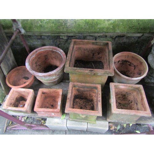 1016 - Eight weathered terracotta planters of varying size and design the largest example 43 cm square appr... 