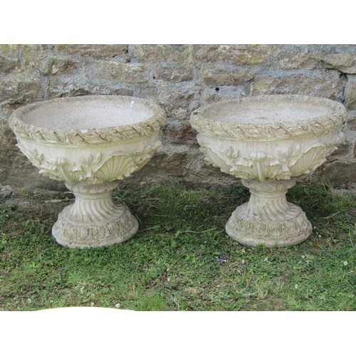 1059 - A pair of weathered cast composition stone garden urns and loose socles with acanthus detail, 48 cm ... 