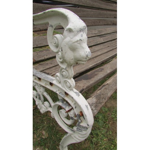 1009 - A two seat garden bench with stained and weathered slats raised on decorative painted cast alloy end... 