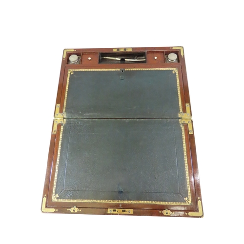 23 - A good William IV mahogany writing slope, with brass banded borders and corners, flanked with flush-... 