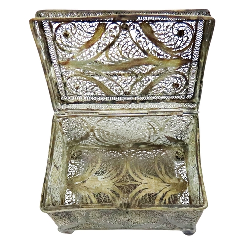 6 - An early continental filigree white metal / silver casket, the hinged cover with swing handle, raise... 