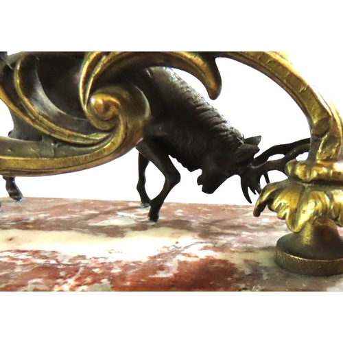 13 - A pair of 19th century continental bronze and ormolu candlesticks, decorated with opposing stags bes... 
