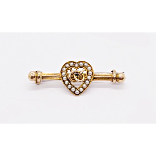 287 - A Victorian 15ct yellow gold bar brooch with loveheart motif bordered with pearls, centred with an e... 
