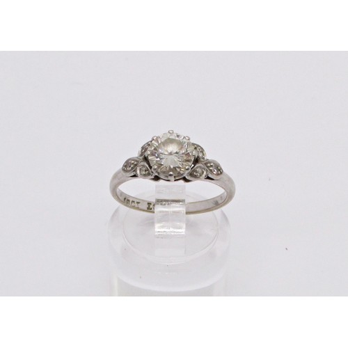 311 - A diamond ring, claw set with a round brilliant cut diamond, approx 1.04ct, with diamond-set foliate... 