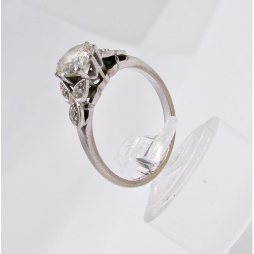311 - A diamond ring, claw set with a round brilliant cut diamond, approx 1.04ct, with diamond-set foliate... 