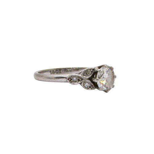 311 - A diamond ring, claw set with a round brilliant cut diamond, approx 1.04ct, with diamond-set foliate... 