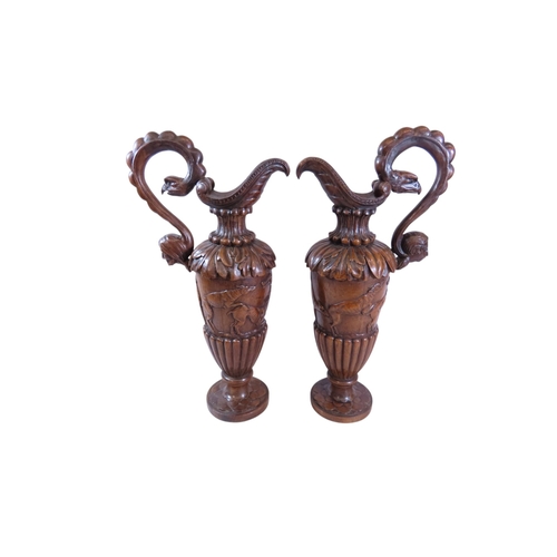 35 - An unusual, large pair of 19th century Italian carved walnut sealed ewers, with swept handles termin... 
