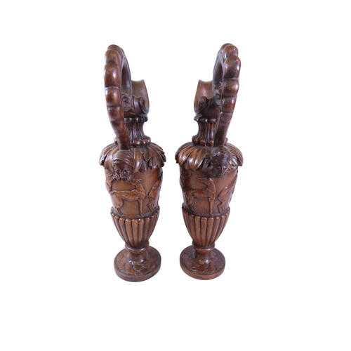 35 - An unusual, large pair of 19th century Italian carved walnut sealed ewers, with swept handles termin... 