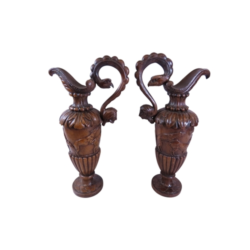 35 - An unusual, large pair of 19th century Italian carved walnut sealed ewers, with swept handles termin... 