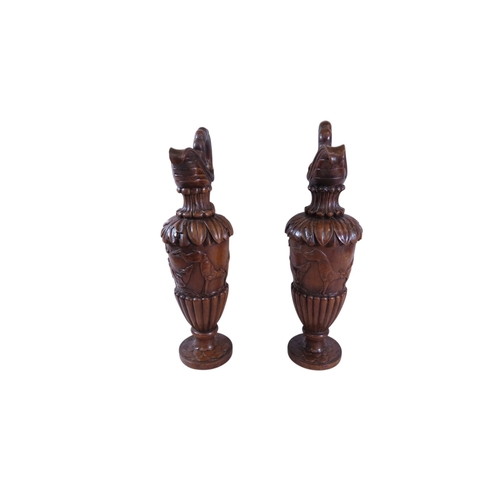 35 - An unusual, large pair of 19th century Italian carved walnut sealed ewers, with swept handles termin... 