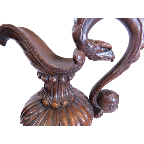 35 - An unusual, large pair of 19th century Italian carved walnut sealed ewers, with swept handles termin... 